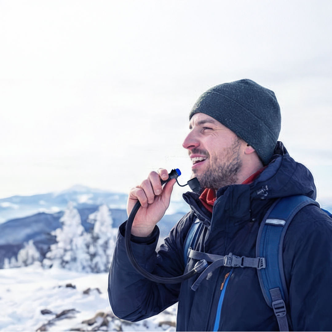 Winter adventurer drinking from an Ever Sip heated hydration tube